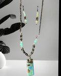 Heartfelt Creations artisan beaded necklace and earring set with turquoise, blue, and brown pendant, accented with crystals.