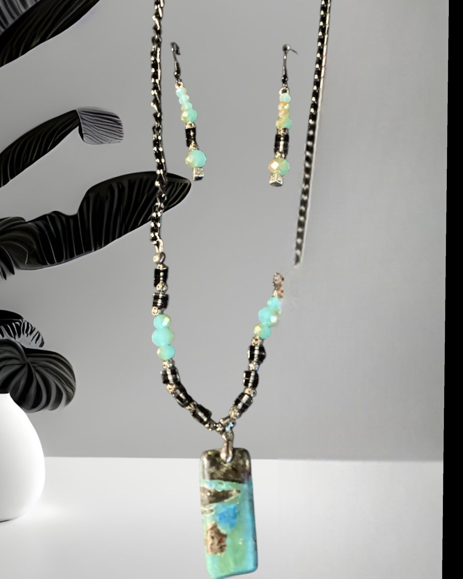 Heartfelt Creations artisan beaded necklace and earring set with turquoise, blue, and brown pendant, accented with crystals.