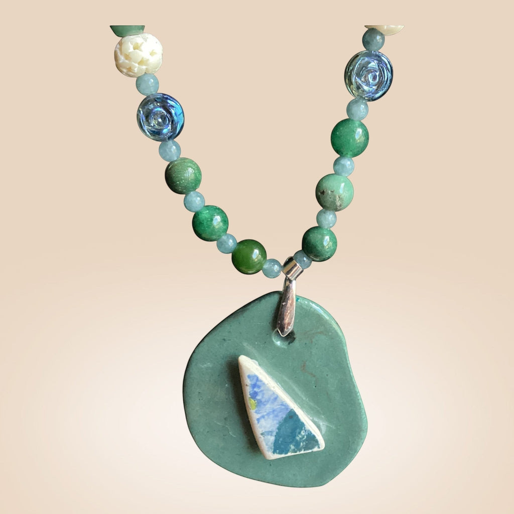 Heartfelt Creations artisan necklace featuring green stones, blue glass beads, and an organic ceramic pendant