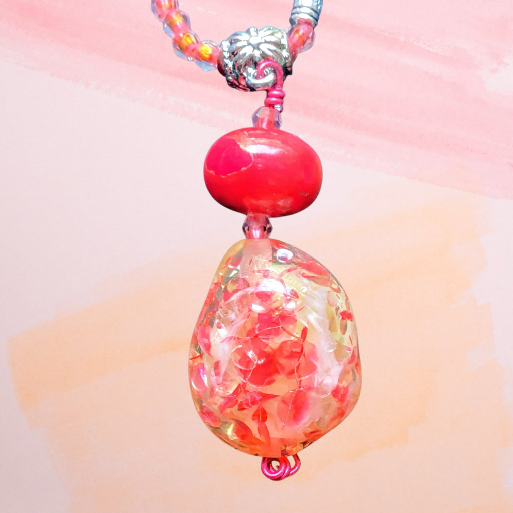 Heartfelt Creations handcrafted beaded pendant necklace with a red glass focal bead and pink coral seed beads.
