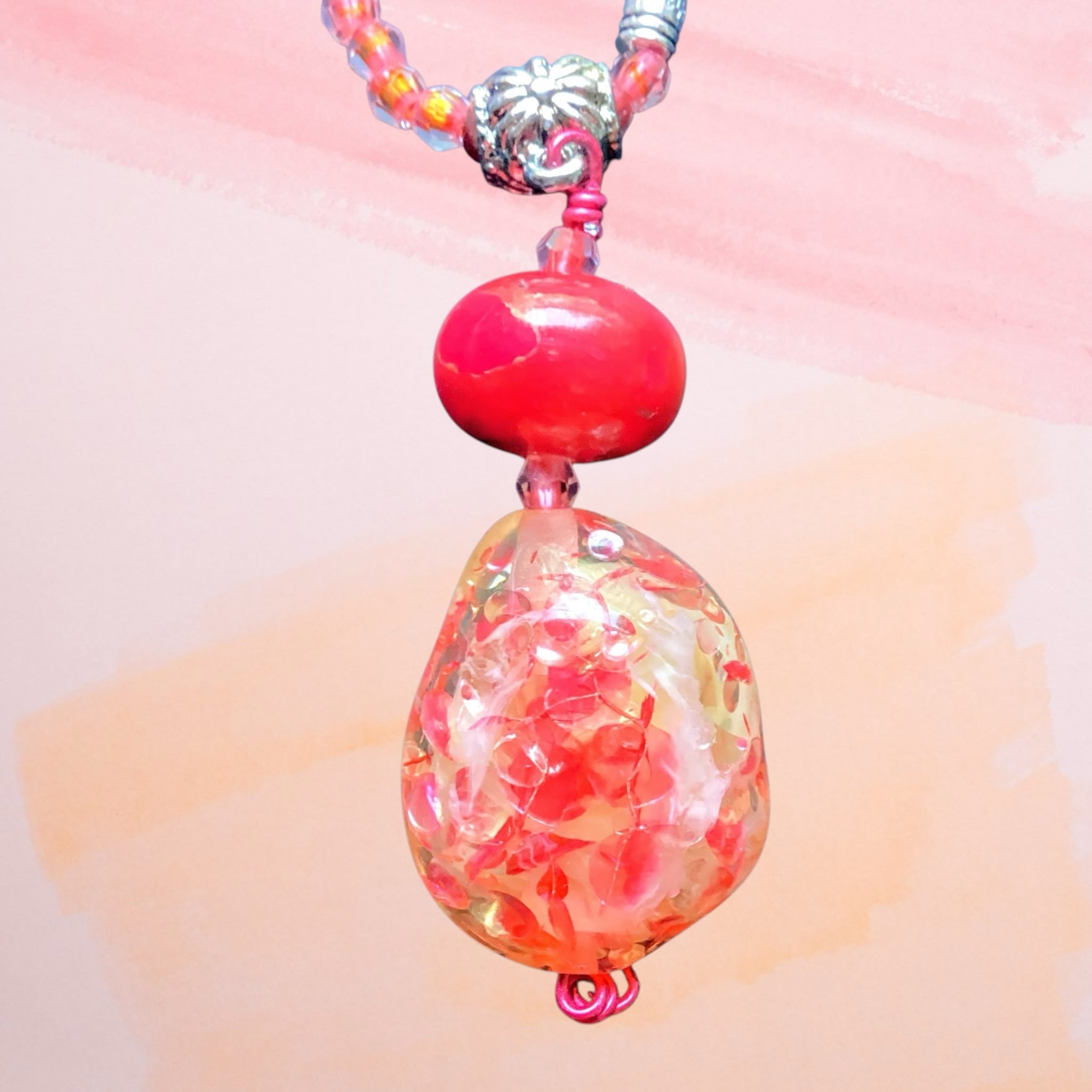 Heartfelt Creations handcrafted beaded pendant necklace with a red glass focal bead and pink coral seed beads.
