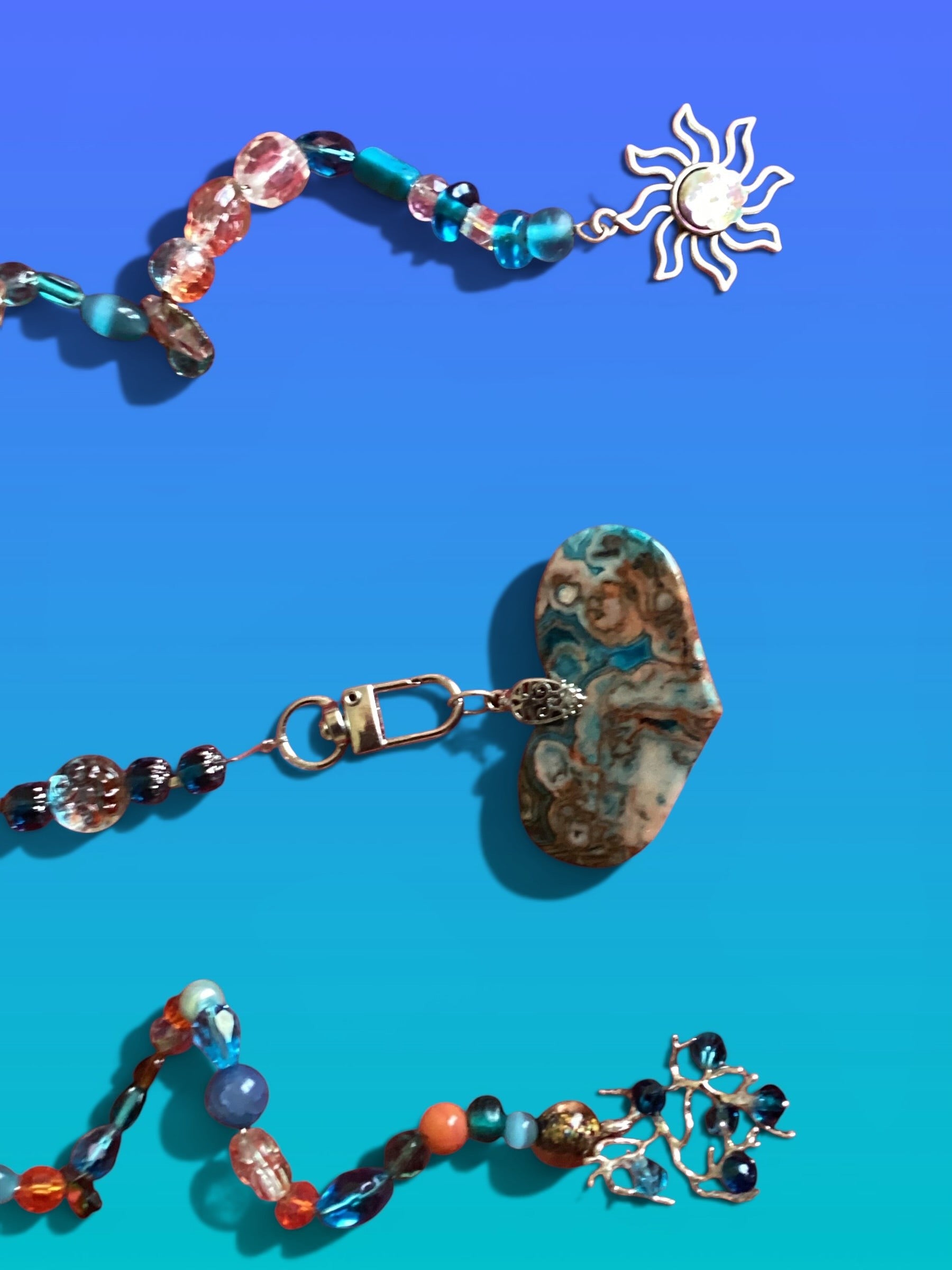 Heartfelt Creations suncatcher with turquoise, gold, and gray beads, a heart stone, and a sun charm.