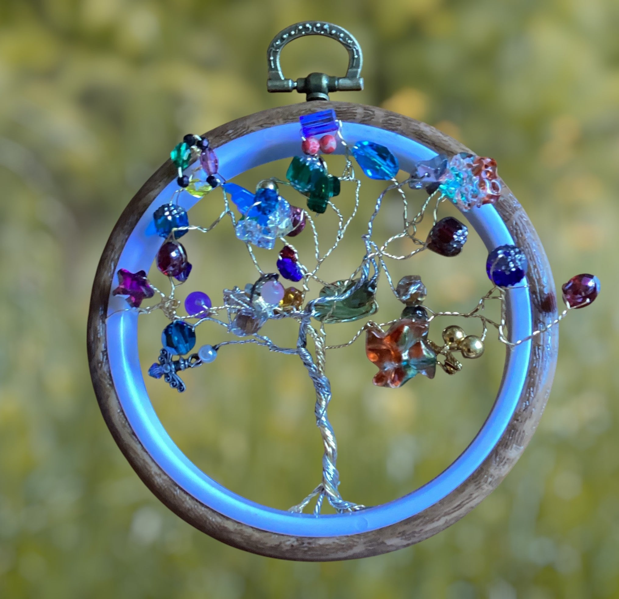 Heartfelt Creations beaded Tree of Life ornament with silver wire, colorful glass beads, crystals, and wooden hoop with blue glow.