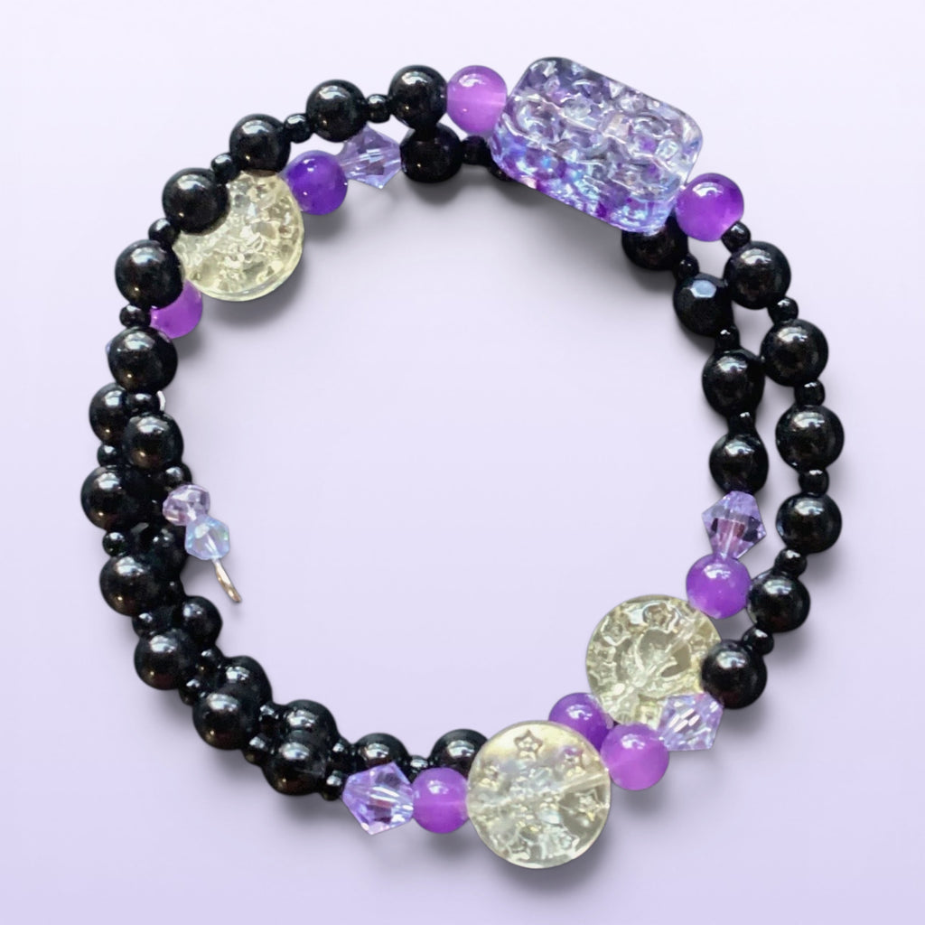 Heartfelt Creations handcrafted wrap bracelet featuring black beads, purple accents, and textured glass elements.