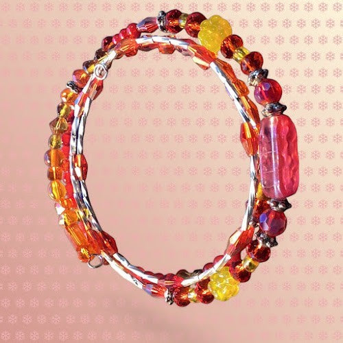 Heartfelt Creations handcrafted wrap bracelet featuring red and yellow glass beads, floral accents, and crystals.