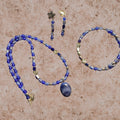 Heartfelt Creations blue beaded jewelry set featuring a pendant necklace, matching bracelet, and floral gold-tone earrings