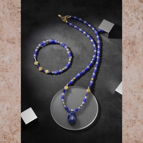 Heartfelt Creations artisan jewelry set featuring a blue beaded necklace with a pendant, matching bracelet, and gold accents