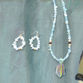 Heartfelt Creations handcrafted jewelry set with light blue gemstone chips, gold accents, and a glass teardrop pendant.