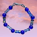 Heartfelt Creations handmade bracelet with cobalt blue glass beads and clear barrel-shaped glass beads with gold flecks.