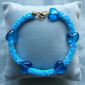 A beaded bracelet featuring a large heart shaped glass bead