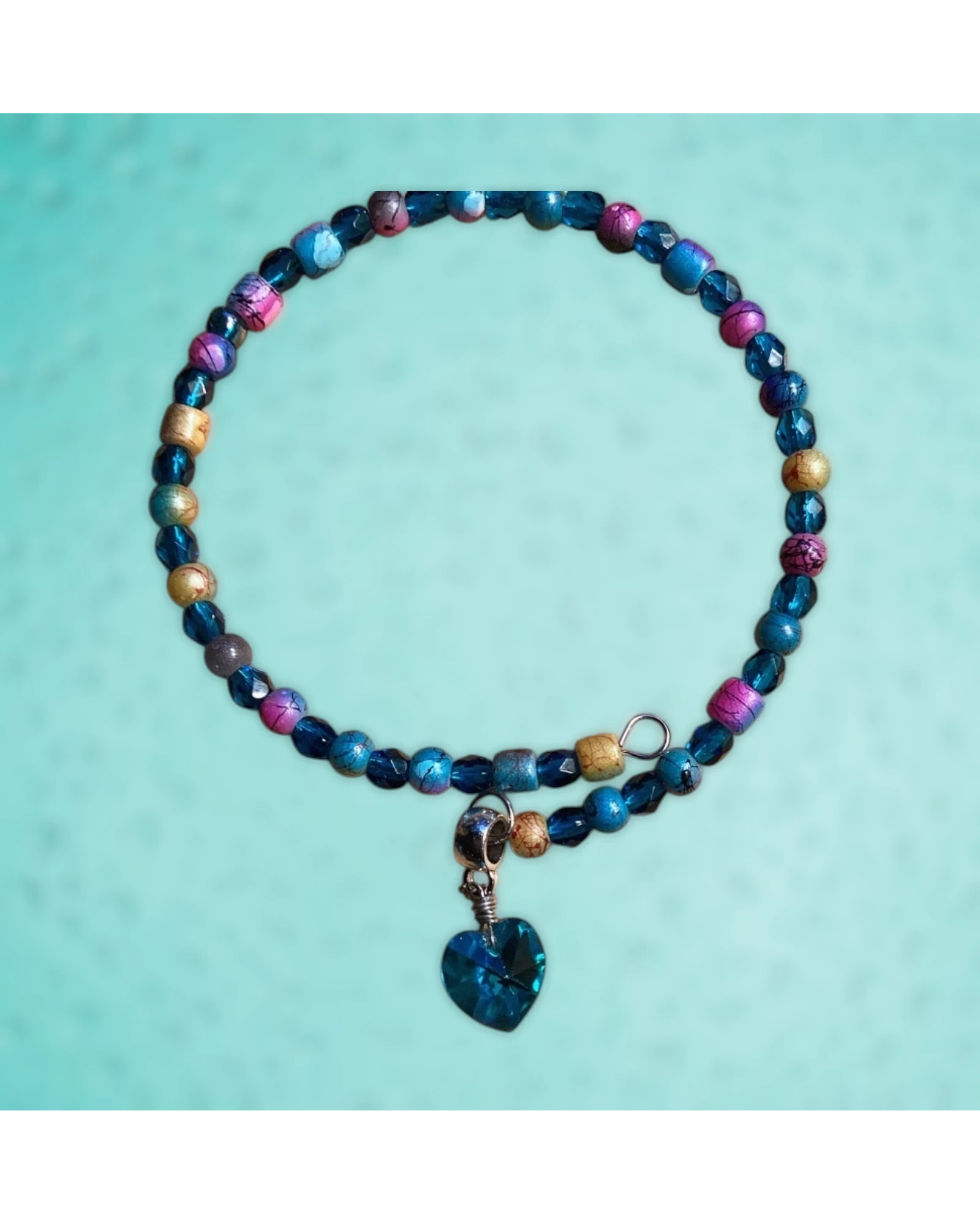 Heartfelt Creations blue, pink, and gold beaded coil bracelet with a blue crystal heart charm.
