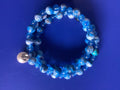 Heartfelt Creations blue swirl beaded coil bracelet with pearl accent. Adjustable wrap design.