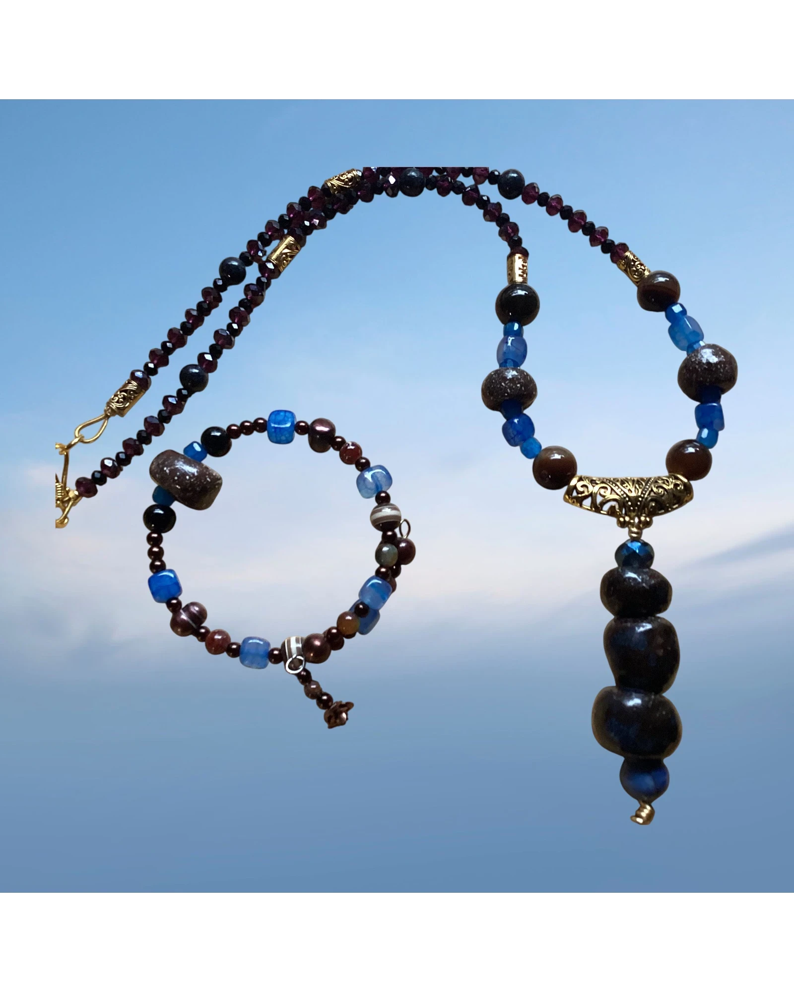 Heartfelt Creations bohemian beaded necklace and bracelet set with deep red, brown, and blue stones. Necklace features a stacked stone pendant.