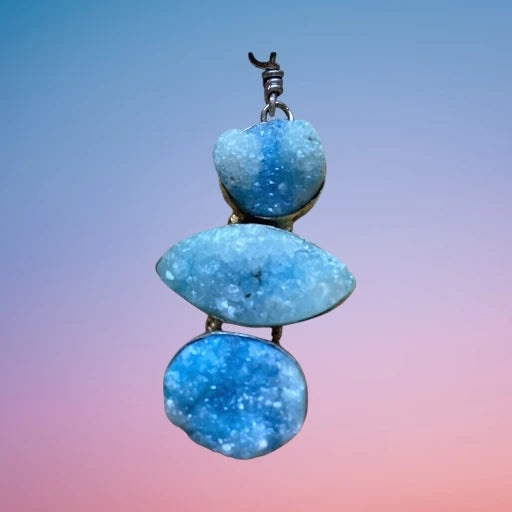A Heartfelt Creations hand-crafted  jewelry set featuring a necklace and matching drop earrings. The necklace has dark teal beads, textured silver beads, a polished silver bar, and three stacked blue agate pendants. Heartfelt Creations bohemian jewelry set with teal pearls, silver rose charms, and blue druzy stones.