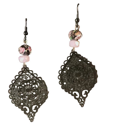 Heartfelt Creations vintage-inspired bronze filigree drop earrings with blush beads and floral accents on pink fabric.