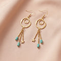 Heartfelt Creations Celestial Charm dangle earrings with hammered gold hoops, turquoise beads, and star charms.