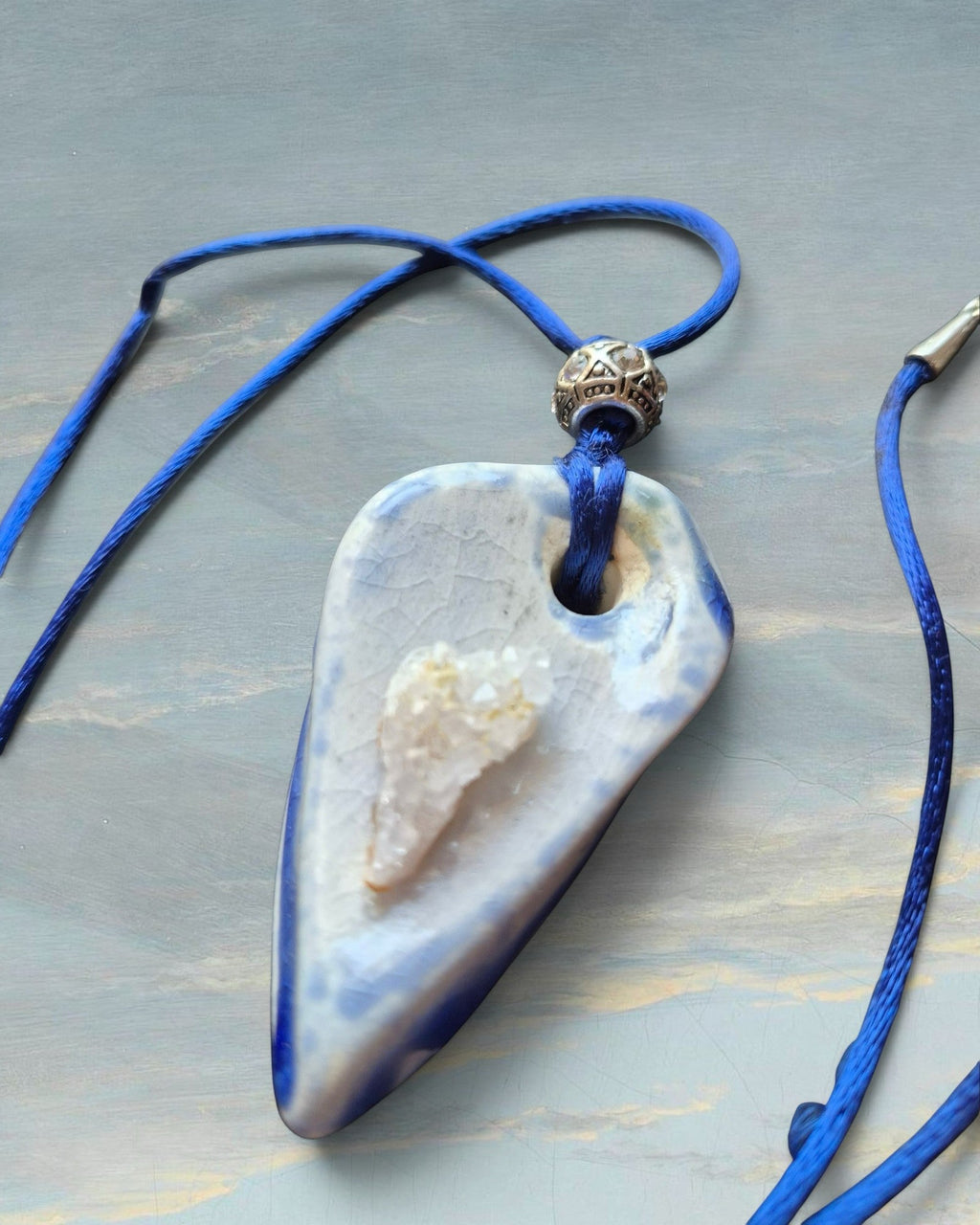Heartfelt Creations artisan ceramic pendant necklace with blue and white crackle glaze, raw crystal, and silver bead.