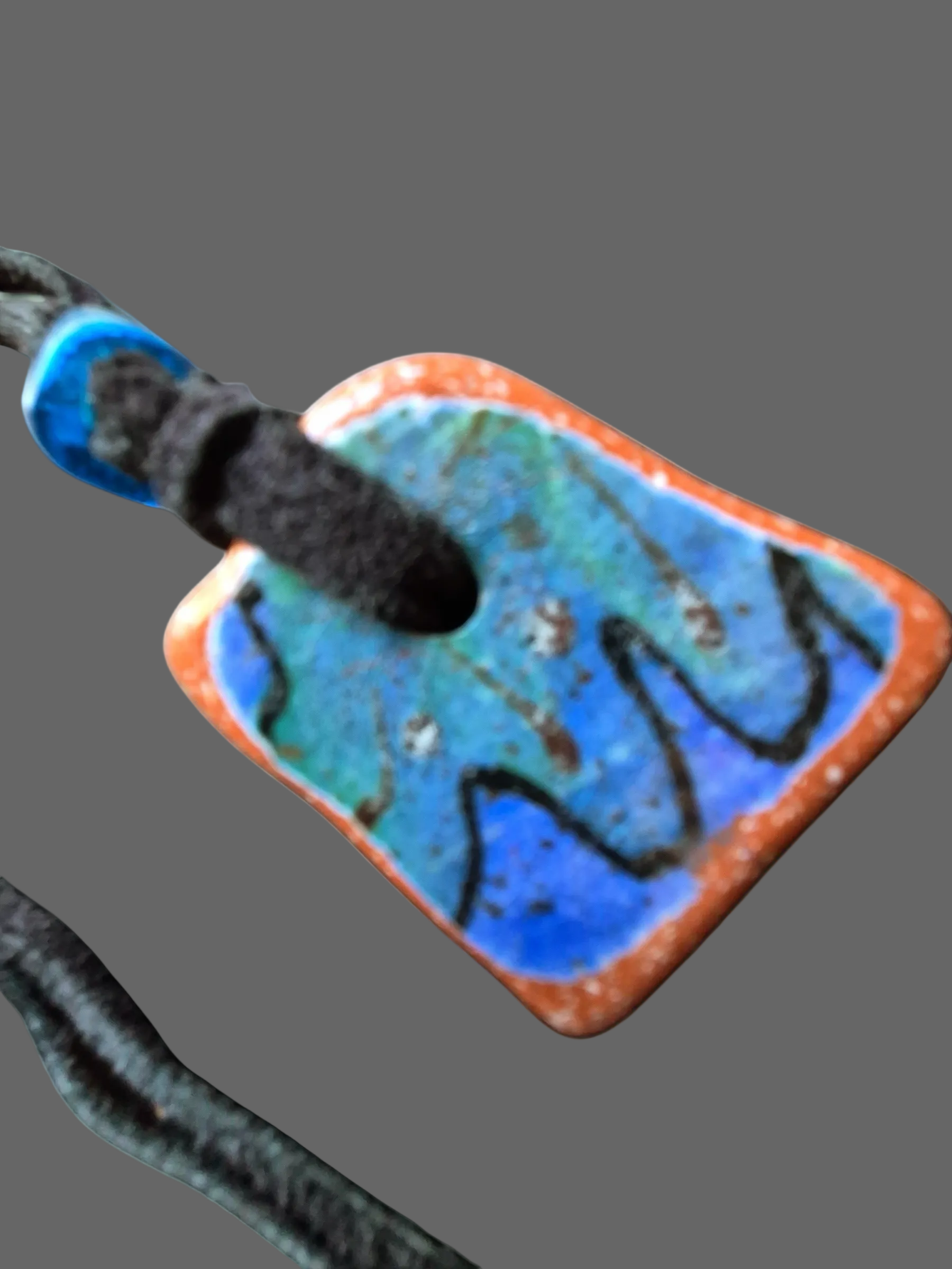 Heartfelt Creations artisan ceramic pendant necklace with blue and orange crackle glaze on a black suede cord.