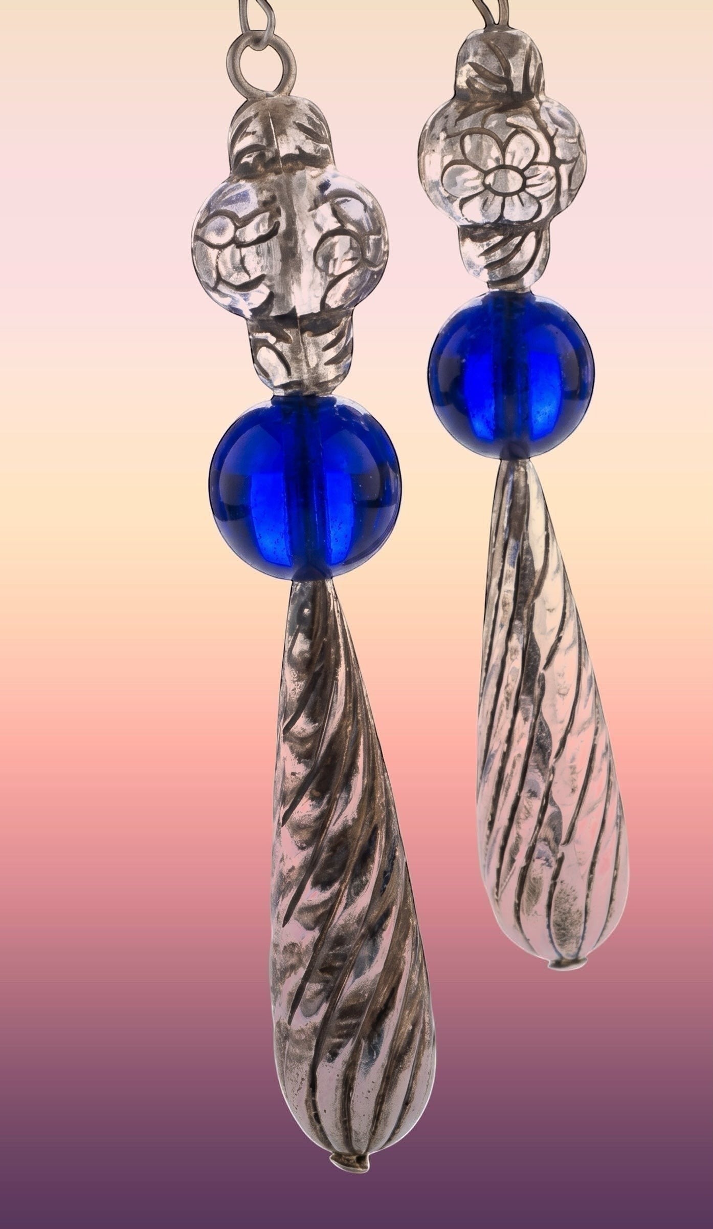 Heartfelt Creations artisan drop earrings featuring silver floral beads, cobalt blue glass spheres, and twisted pendants.
