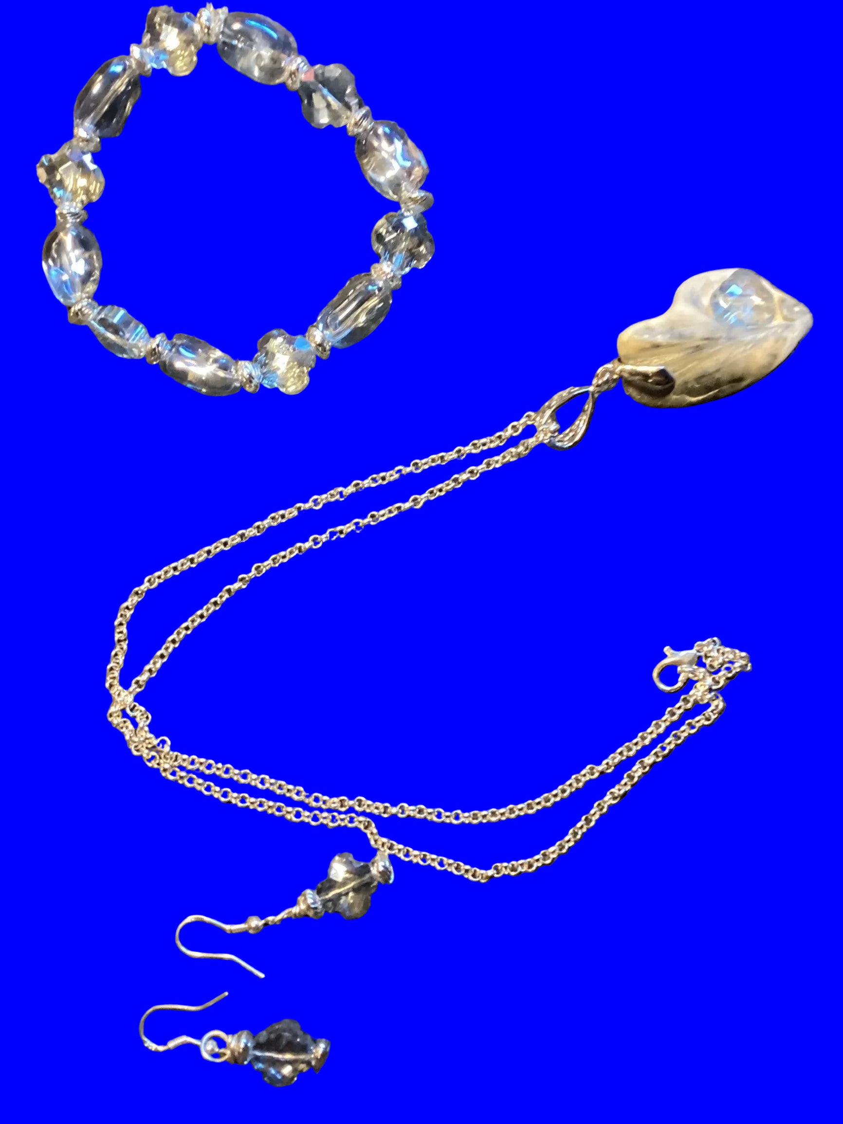 Heartfelt Creations silver-tone jewelry set with blue-grey crystal beads, iridescent pendant necklace, drop earrings, and bracelet.
