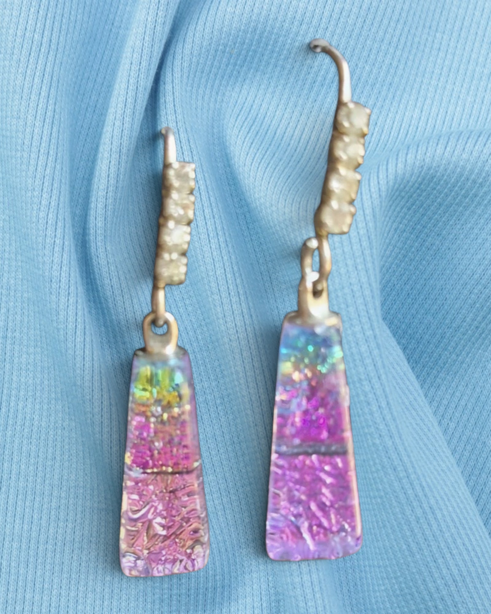 Heartfelt Creations dichroic glass drop earrings with pink and purple trapezoidal pendants on textured metal hooks.