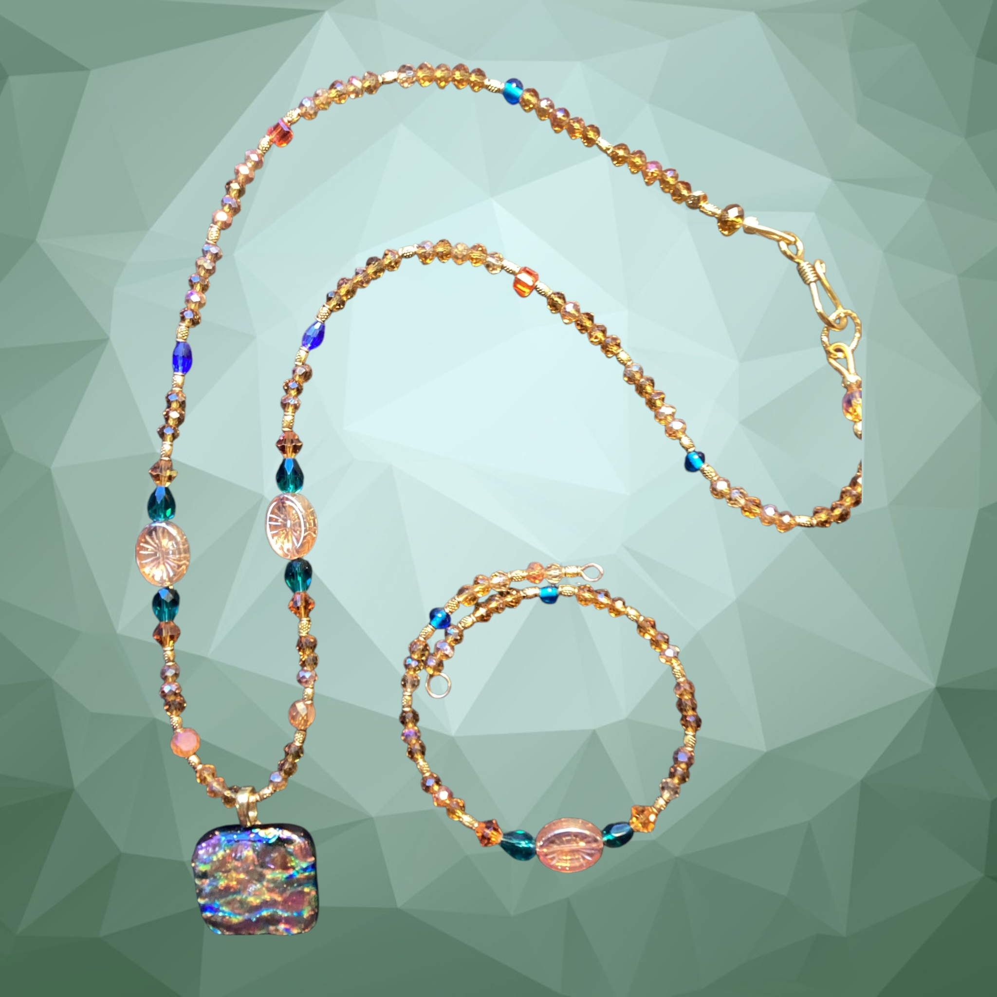 Heartfelt Creations artisan necklace and bracelet set featuring a dichroic glass pendant with amber and teal beads.