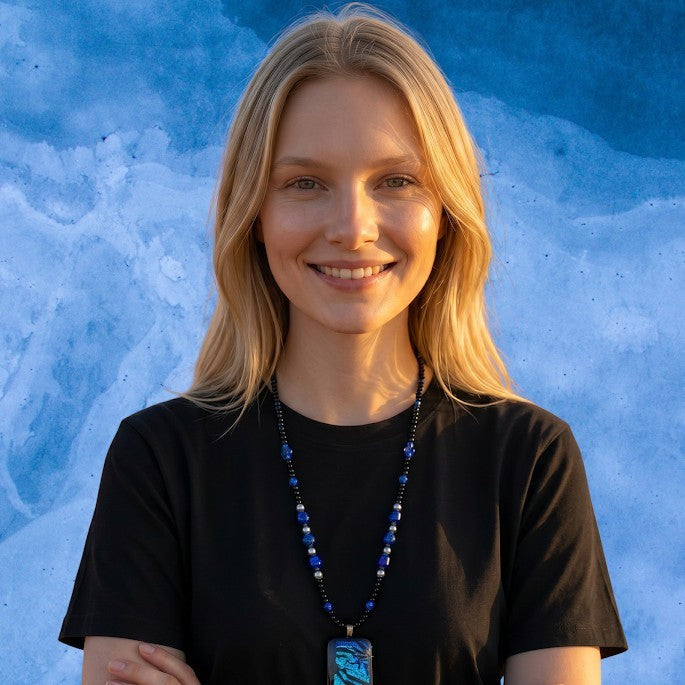 Heartfelt Creations artisan dichroic glass pendant necklace with blue and violet beads on a smiling blonde model