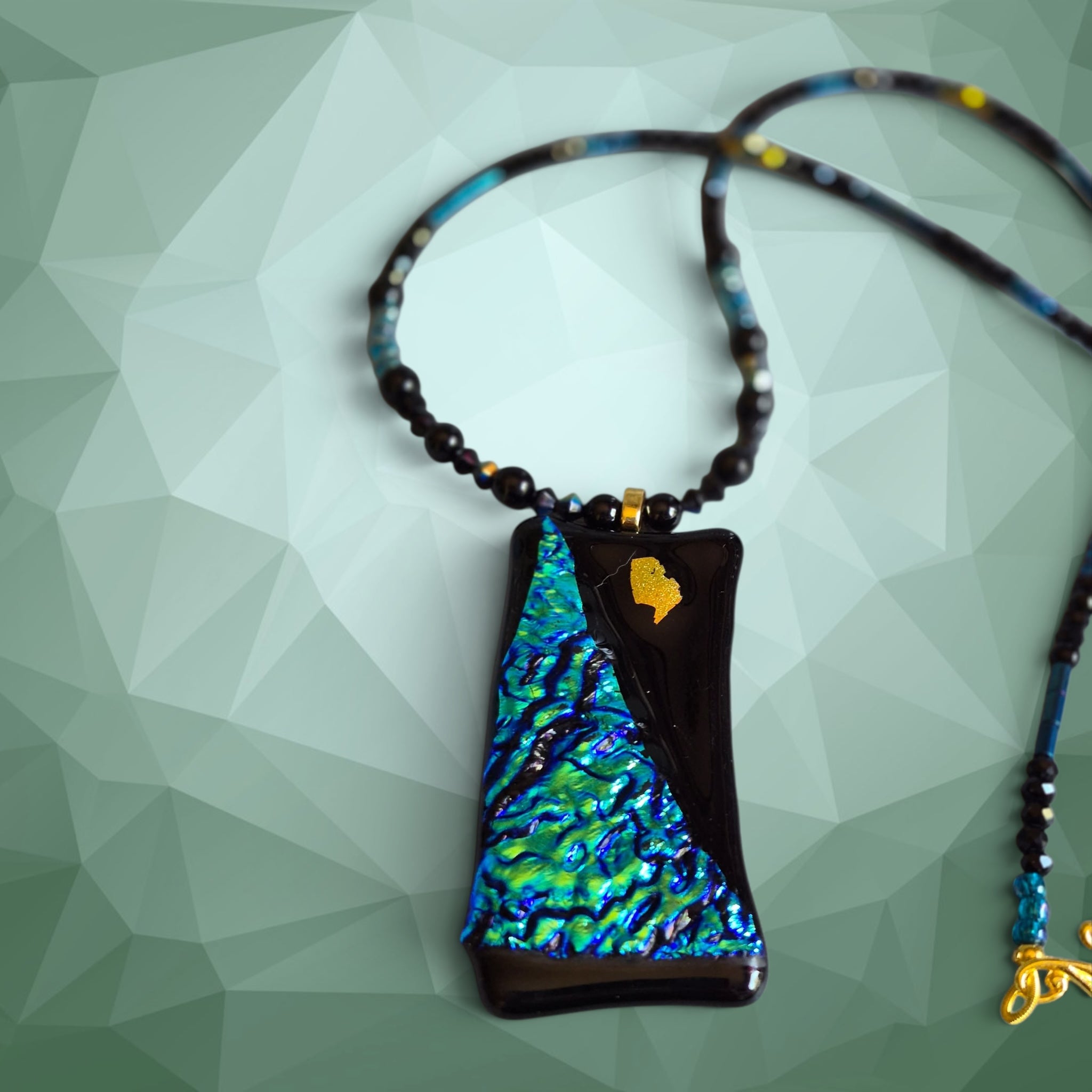 Heartfelt Creations artisan necklace featuring a dichroic glass pendant with iridescent blue and green on black glass.