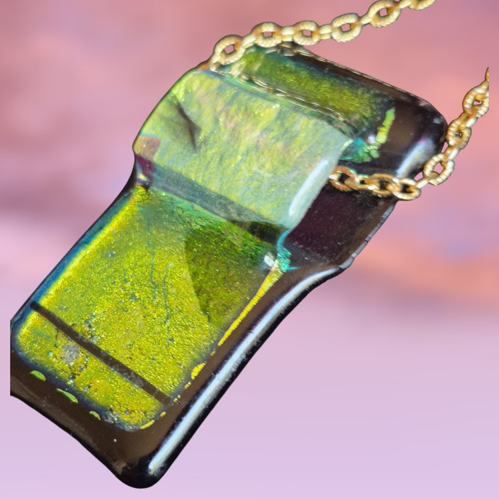 Heartfelt Creations handcrafted dichroic glass pendant necklace featuring iridescent green and black fused glass on a gold chain.