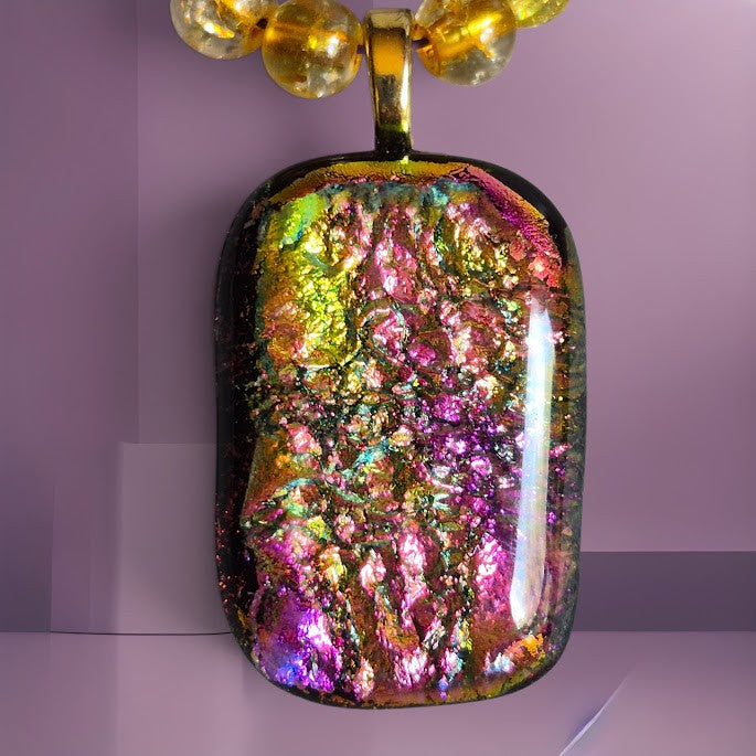 Heartfelt Creations dichroic glass pendant in iridescent pink, gold, and green with amber beads on a black cord