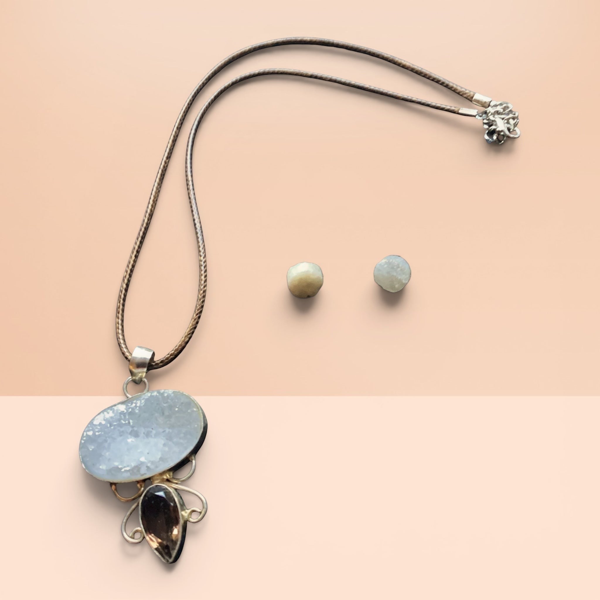 Heartfelt Creations jewelry set featuring a blue druzy and smoky quartz pendant on a braided cord with matching stud earrings