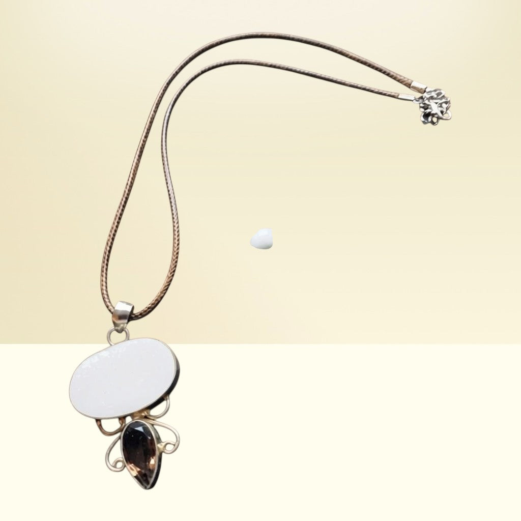 Heartfelt Creations artisan necklace with oval blue druzy, smoky quartz drop, and silver filigree on a braided cord.