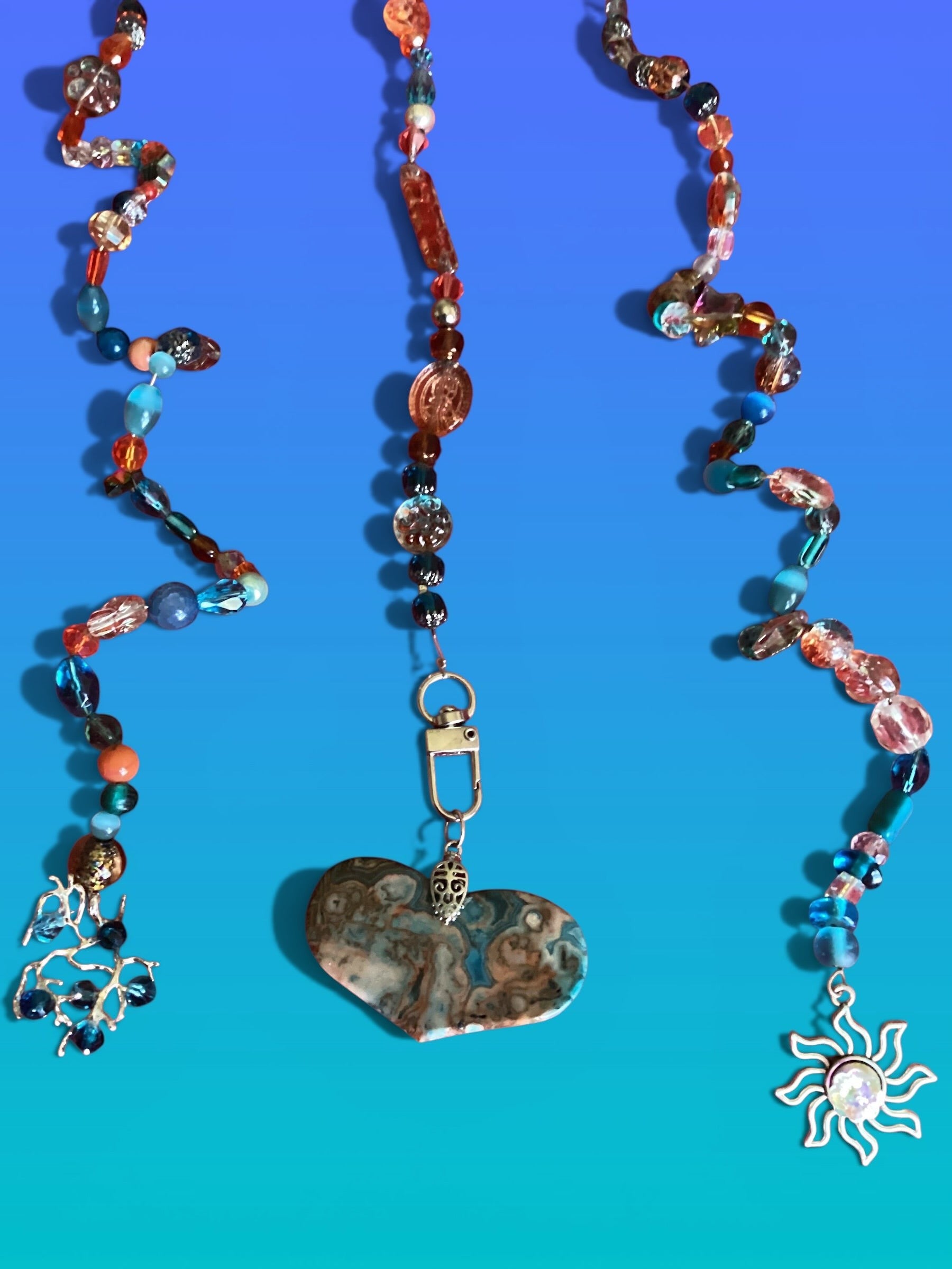 Heartfelt Creations exotic suncatcher with turquoise, gold, and gray beads, a heart stone, and a sun charm.
