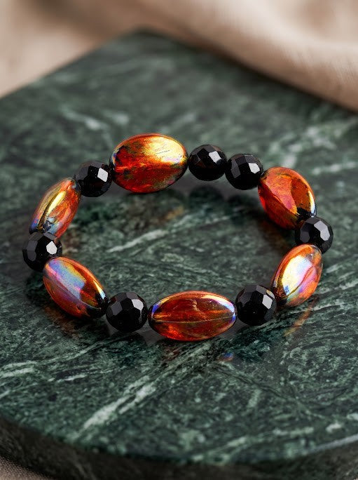 Heartfelt Creations artisan bracelet featuring fiery orange, red, and gold oval beads with black faceted accents.