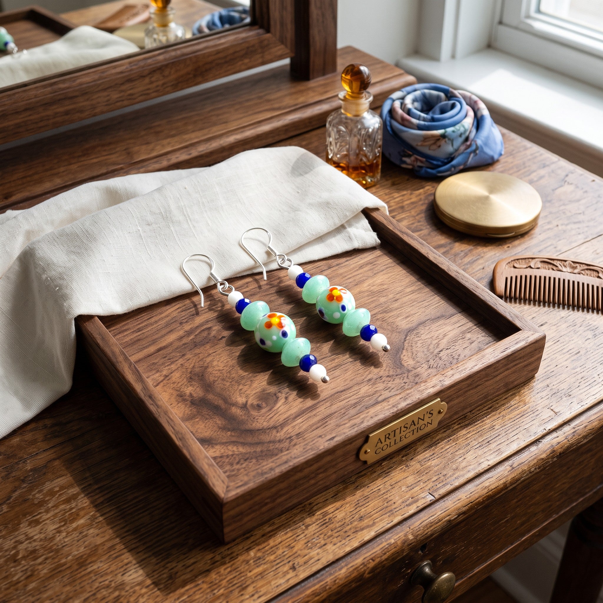 Heartfelt Creations handcrafted dangle earrings with mint green, purple, and white floral beads on a wooden tray.
