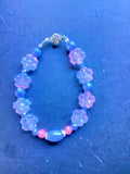 Heartfelt Creations floral beaded charm bracelet with iridescent floral charms, lavender, blue, and pink beads.