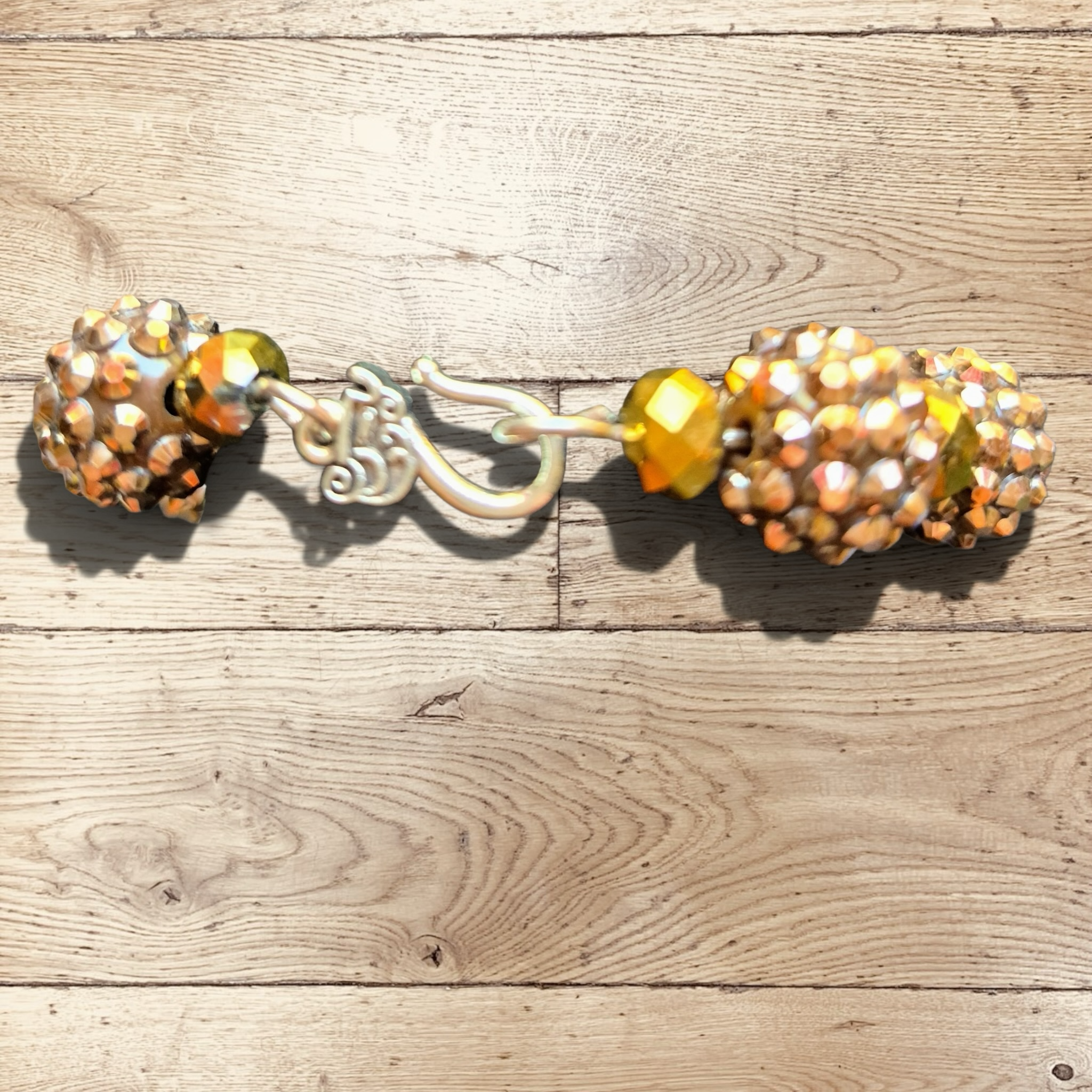 Heartfelt Creations handmade bracelet with iridescent marbled beads, gold-tone faceted beads, and champagne rondelles. Silver-tone clasp.