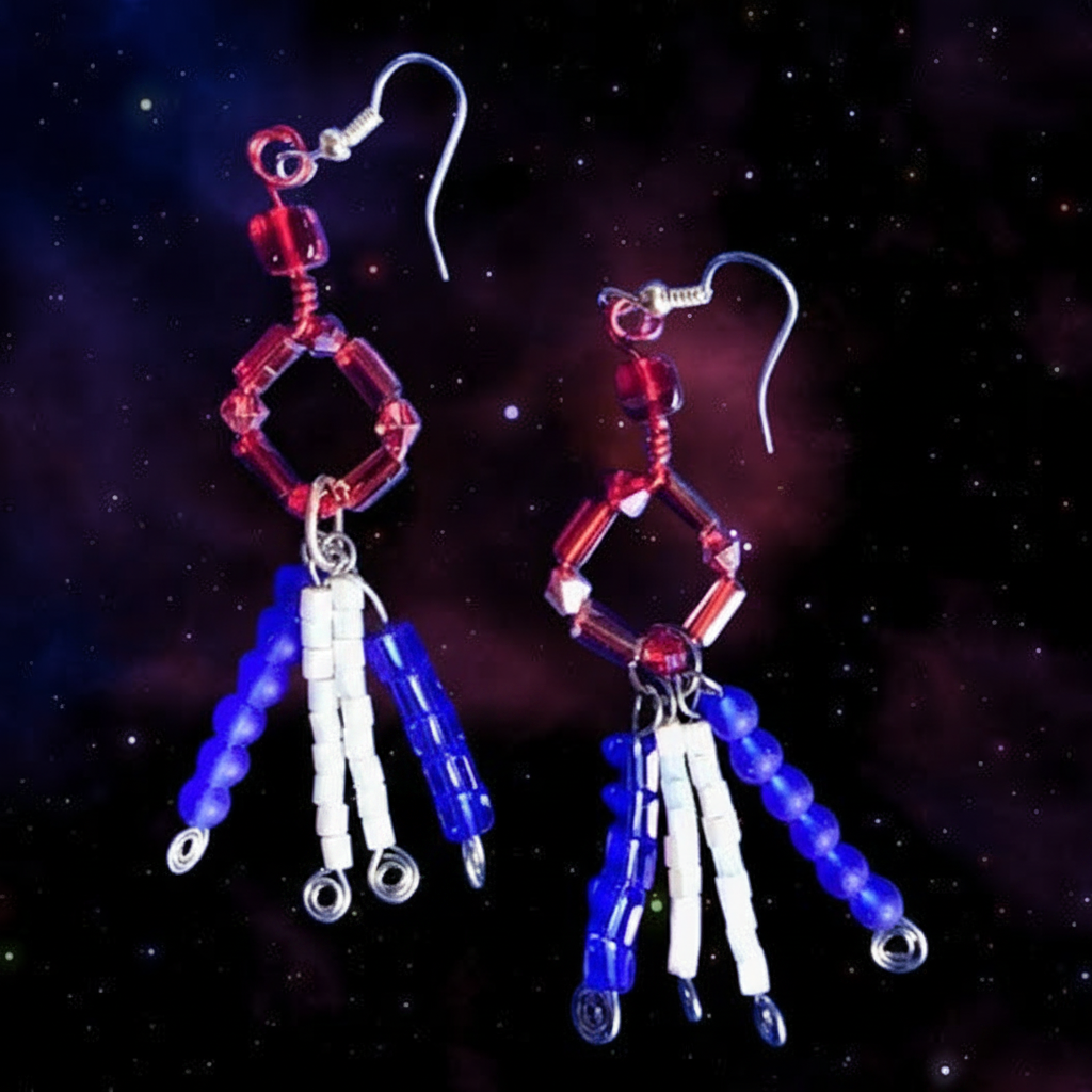 A pair of beaded dangle earrings with red hexagonal beads, silver fishhook wires, and dangling strands of blue, white, and red beads, set against a dark starry space background.