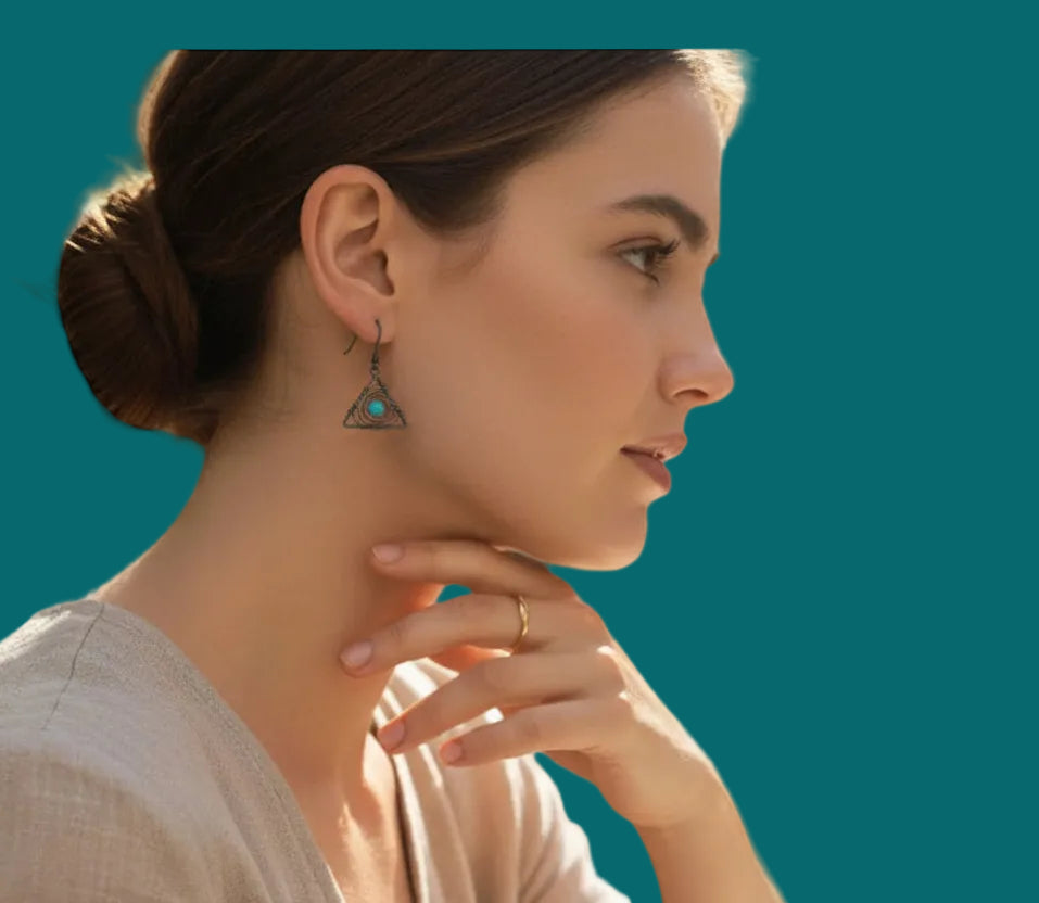 Heartfelt Creations handcrafted geometric wire-wrapped earrings with a turquoise bead worn by a woman in profile