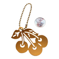 A gold-colored metal cherry keychain with a ball chain and a cherry cutout pendant, shown next to a US quarter for scale on a white background.