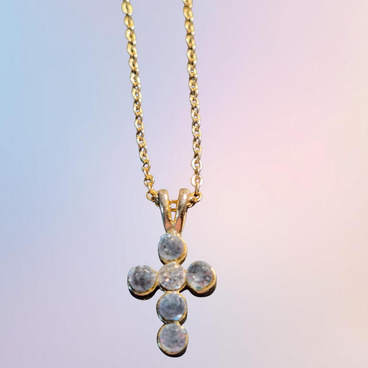 Heartfelt creations, dainty cross with a lovely blue grey cubic zirconium stones, hanging from a golden chain.