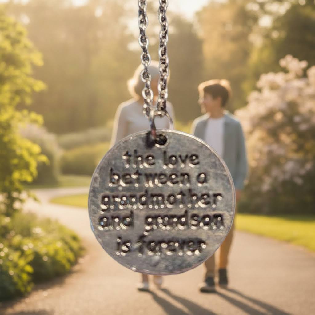 A silver-stainless steel round pendant necklace with engraved text reading 'the love between a grandmother and grandson is forever.'