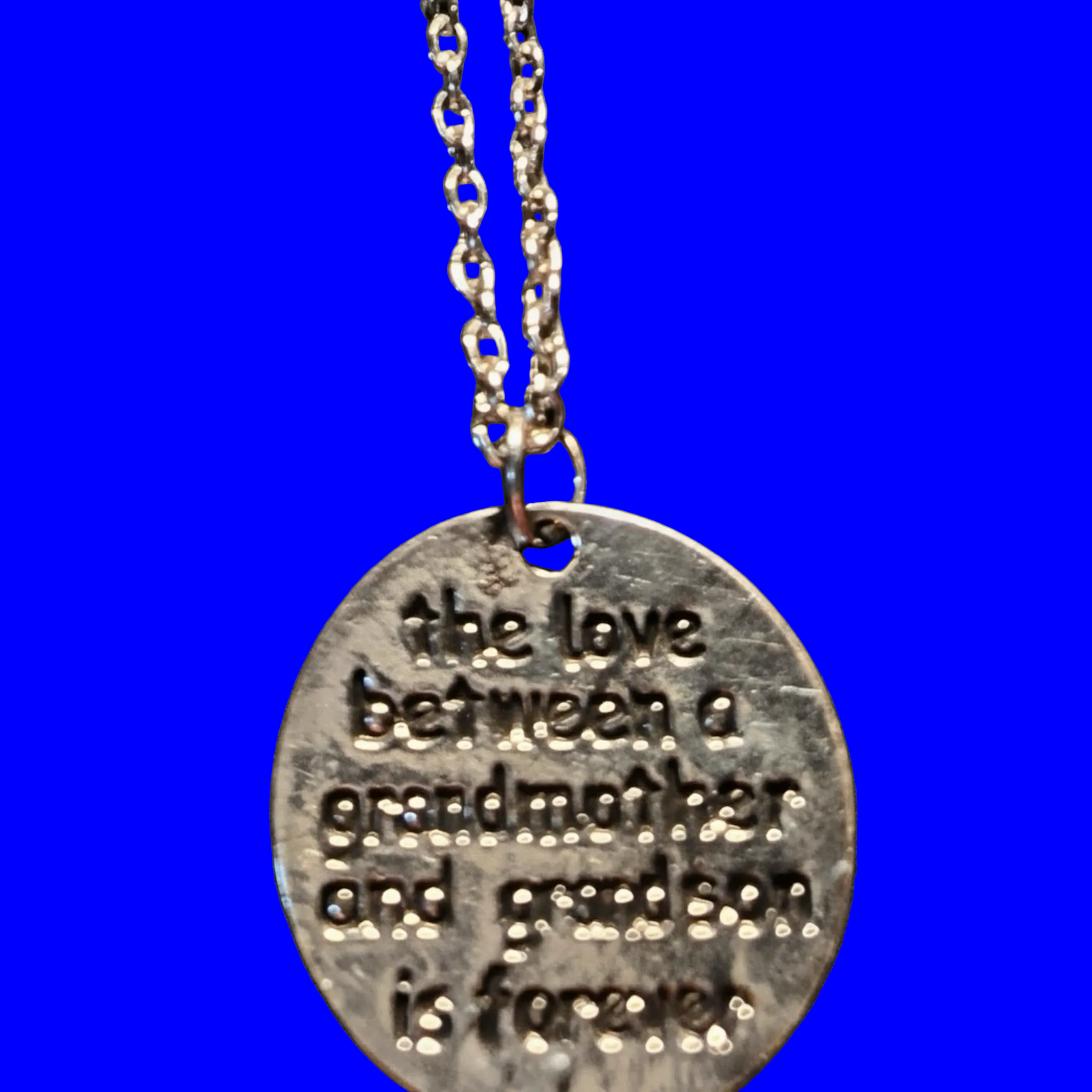 Heartfelt Creations silver-toned metal pendant necklace engraved with 'the love between a grandmother and grandson is forever'.