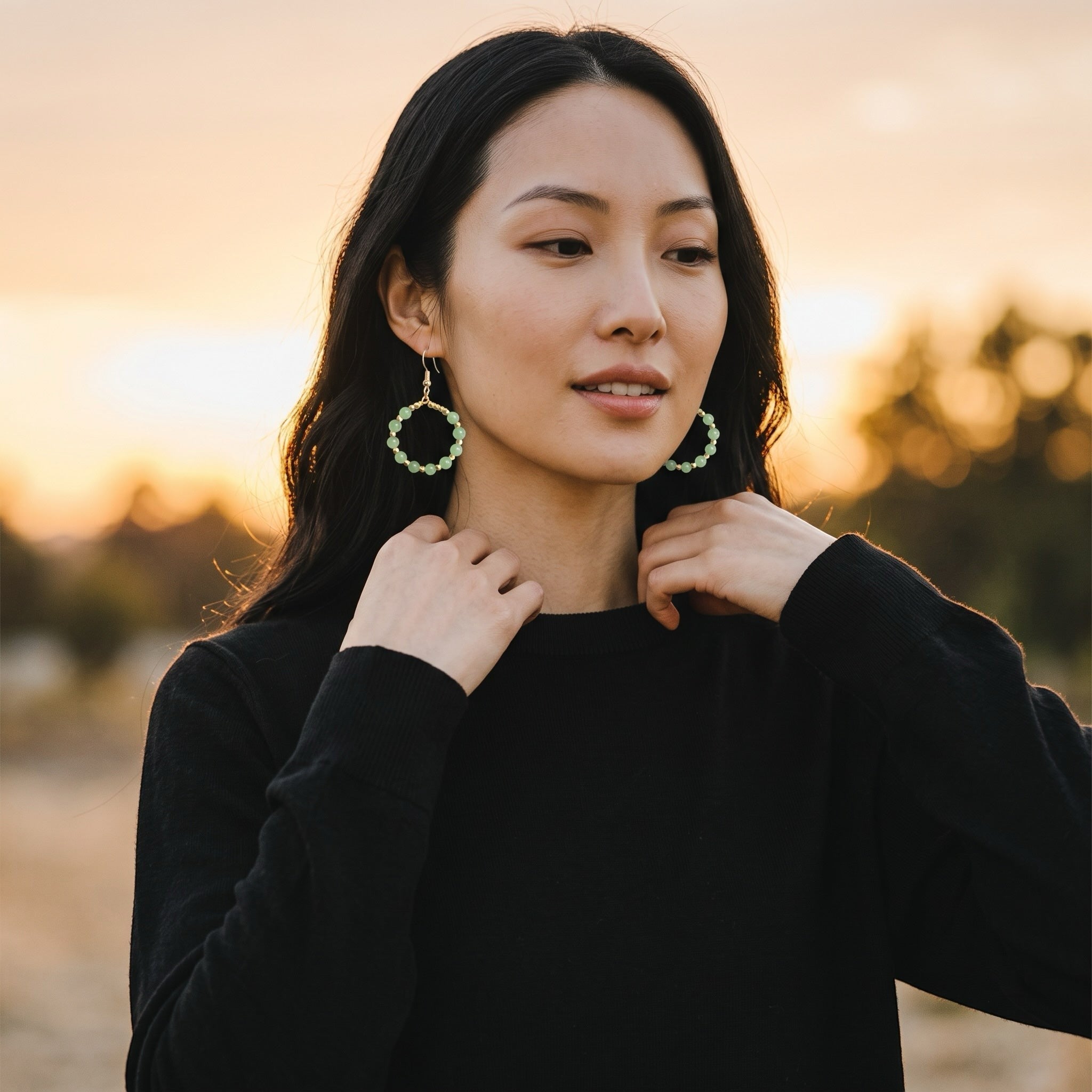 Heartfelt Creations handcrafted hoop earrings with soft green gemstone beads and gold accents worn by a woman