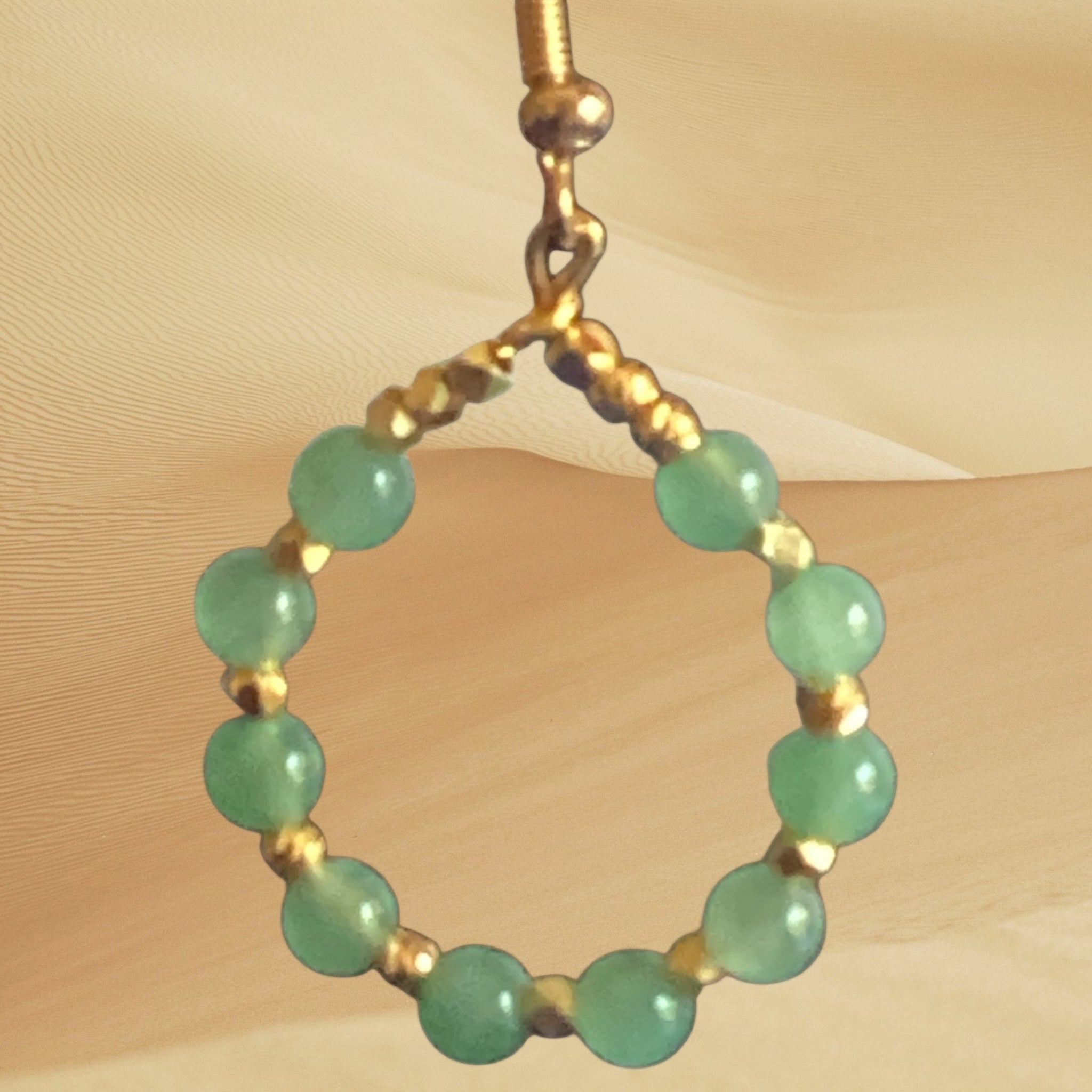 Heartfelt Creations handcrafted hoop earrings featuring smooth green gemstone beads and gold-tone metallic spacers.