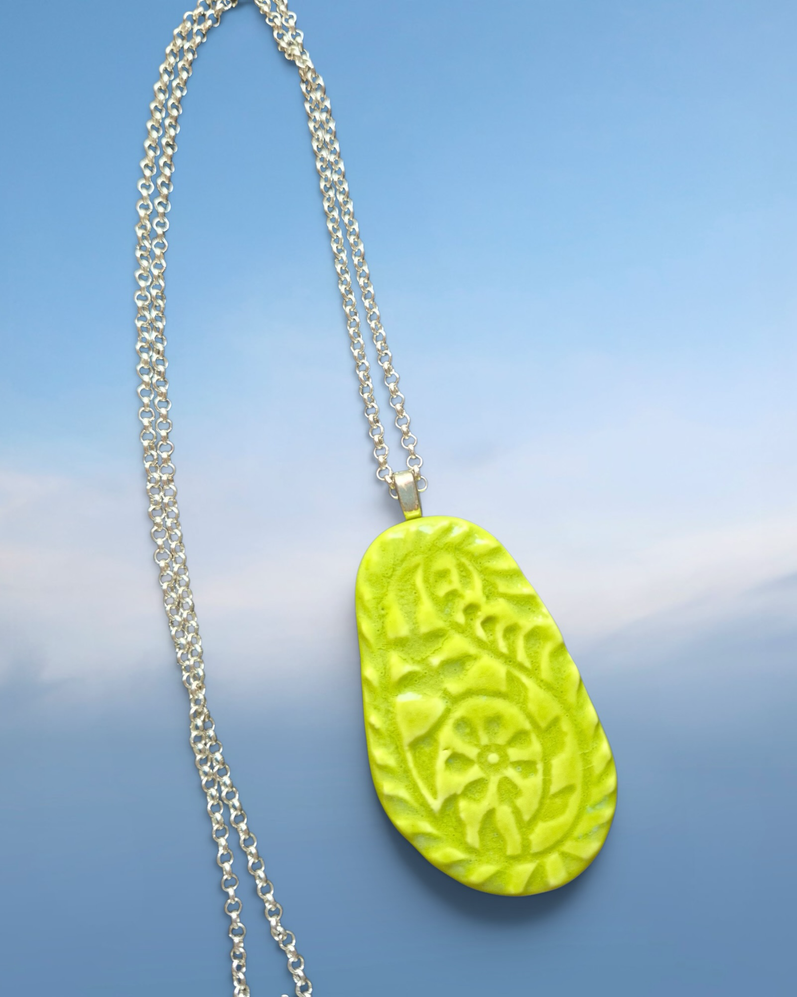Heartfelt Creations lime green pendant necklace with embossed floral pattern on a silver-toned chain.
