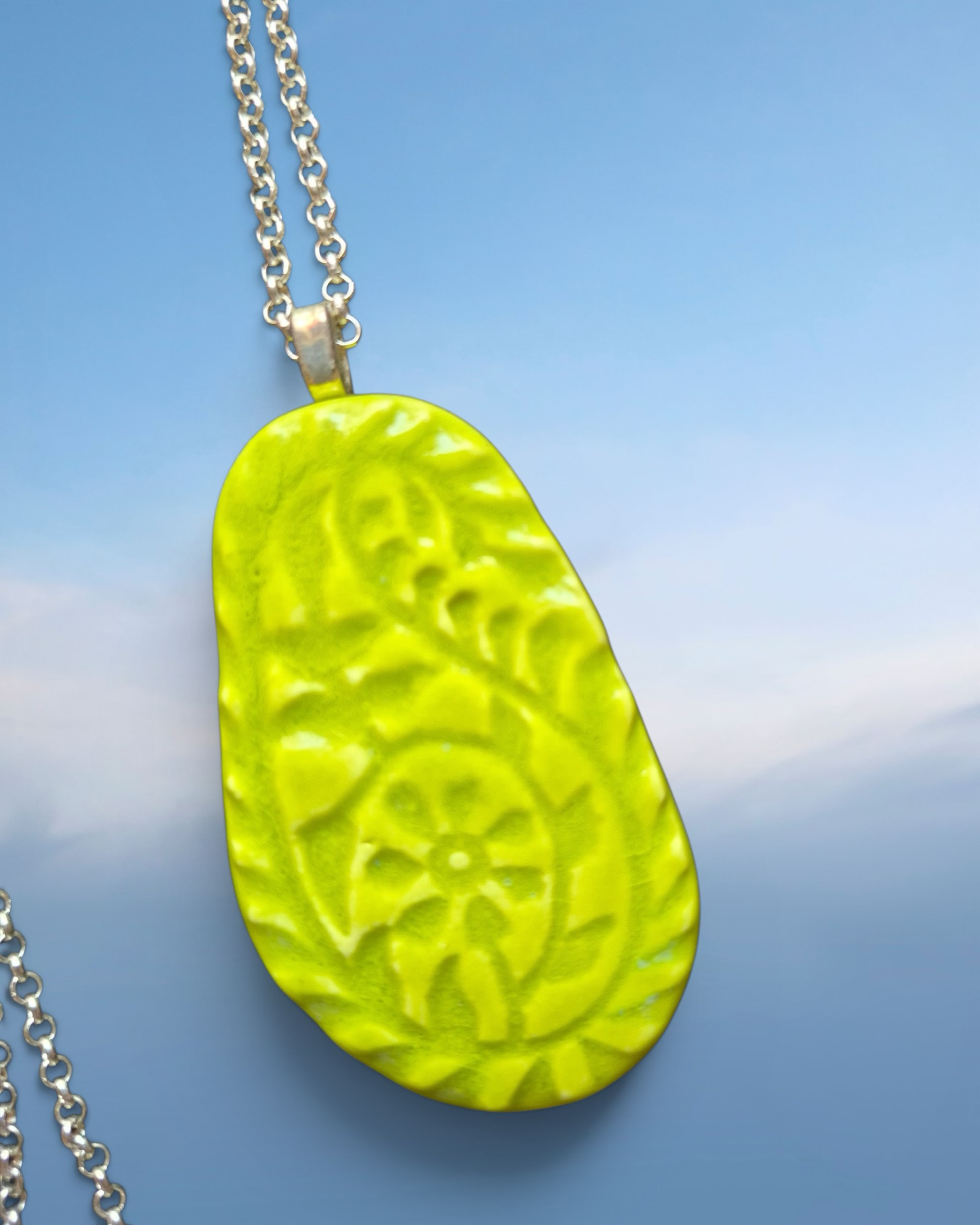 Heartfelt Creations lime green pendant necklace with embossed floral pattern on a silver-toned chain.