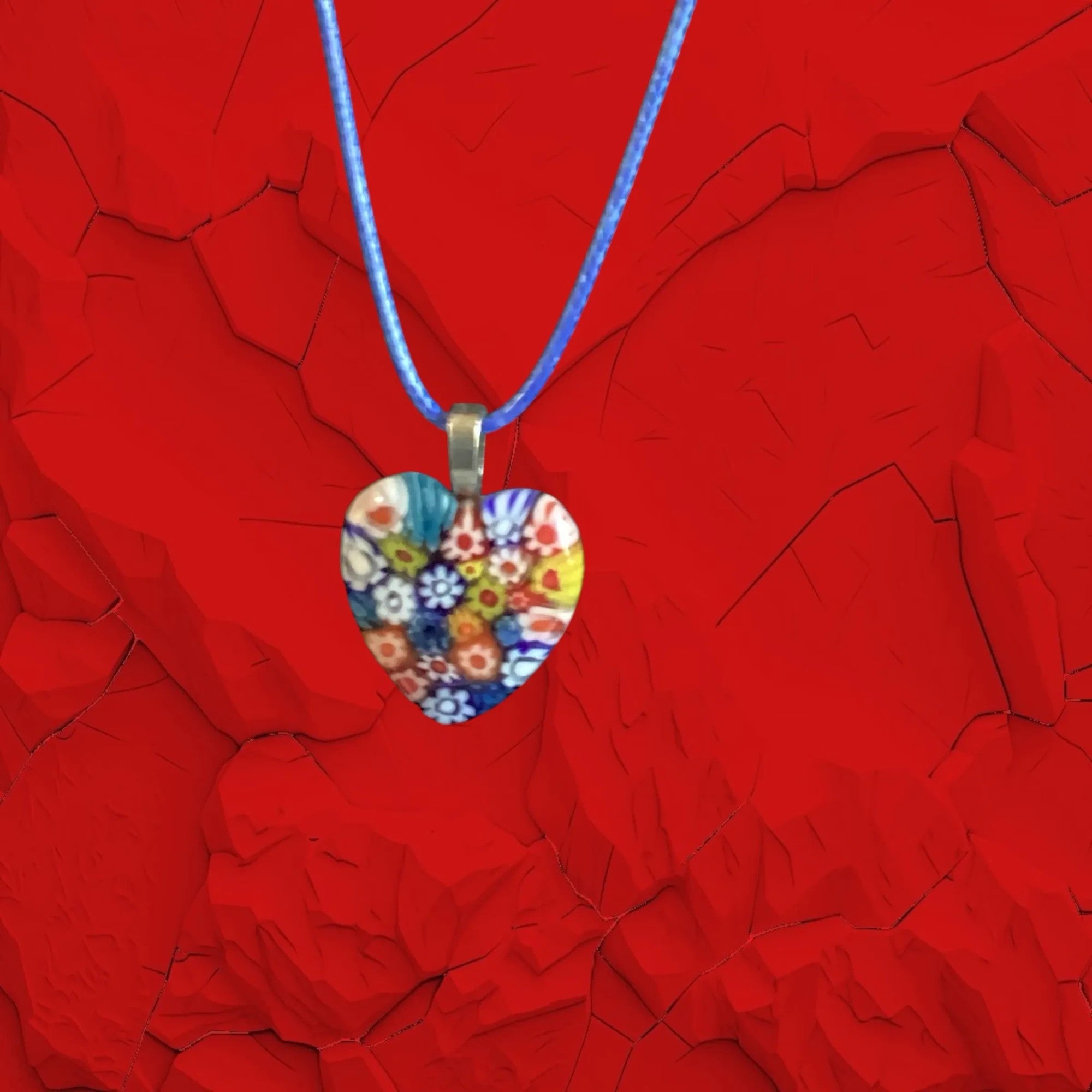 Heartfelt Creations heart-shaped Millefiori glass pendant necklace with colorful floral pattern on blue cord.
