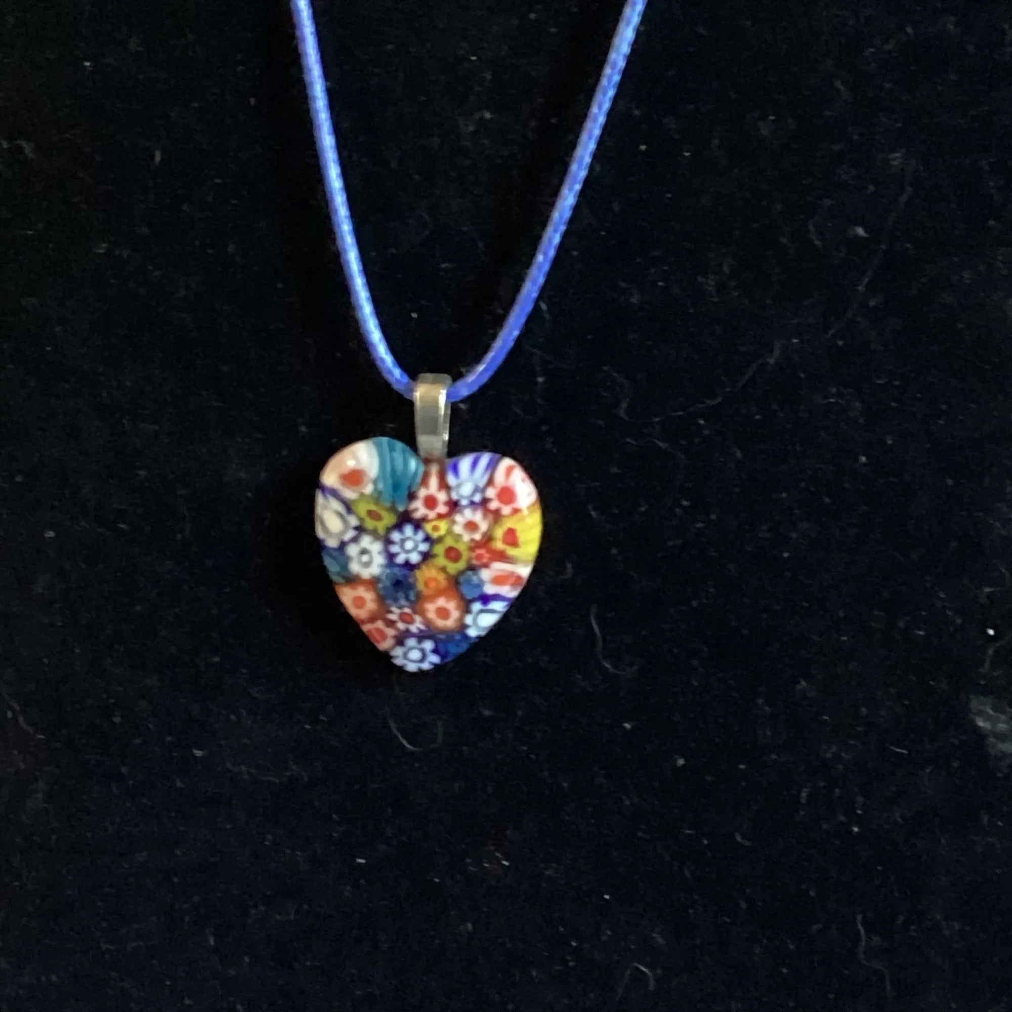 Heartfelt Creations heart-shaped Millefiori glass pendant necklace with colorful floral pattern on blue cord.