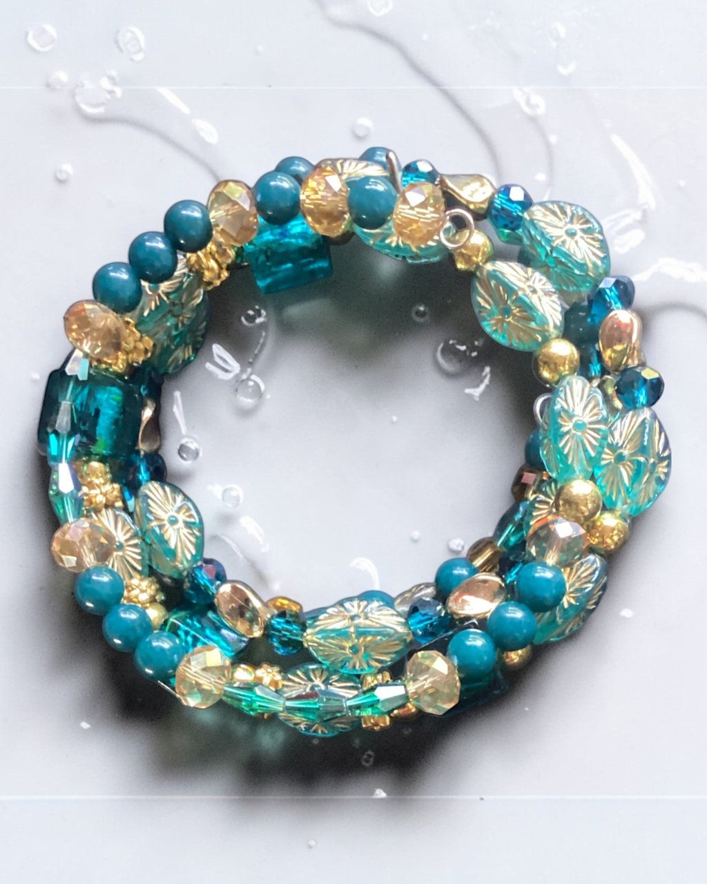 Heartfelt Creations Ocean Jewel beaded bracelet set with teal, gold, and crystal beads, featuring floral glass beads and faceted crystals.